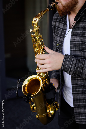 Hands of young musician man plays on saxophone