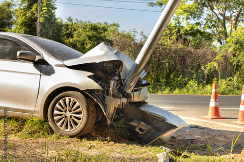 The white sedan was involved in a collision with an electric pole.