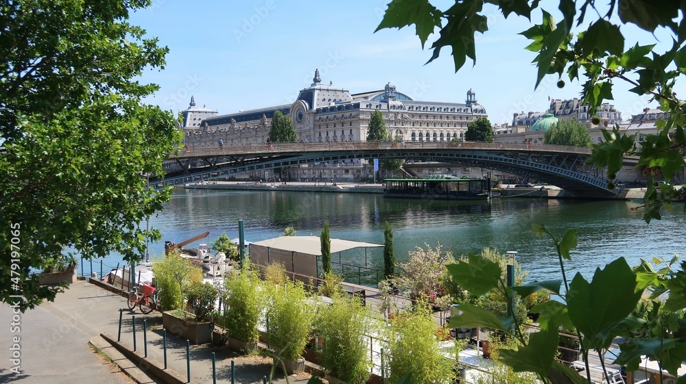 Paysage urbain dans la ville de Paris, vue sur le musée d’Orsay et le pont passerelle Léopold Sédar-Senghor sur la Seine, avec des arbres (France) Paysage urbain dans la ville de Paris, vue sur le musée d’Orsay et le pont passerelle Léopold Sédar-Senghor sur la Seine, avec des arbres (France)