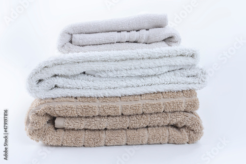 Stack of folded clean soft towels on white