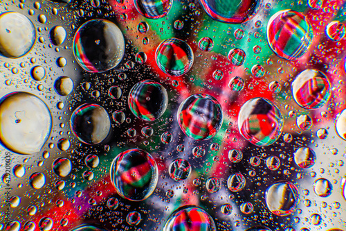 Water droplets on a glass in form of lenses with a colourful background. Wallpaper for screen. Abstract background.