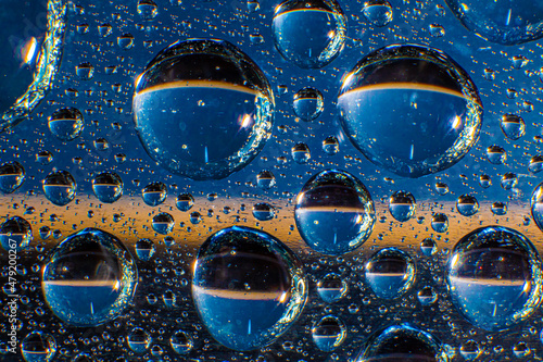 Water droplets on a glass in form of lenses with a colourful background. Wallpaper for screen. Abstract background.