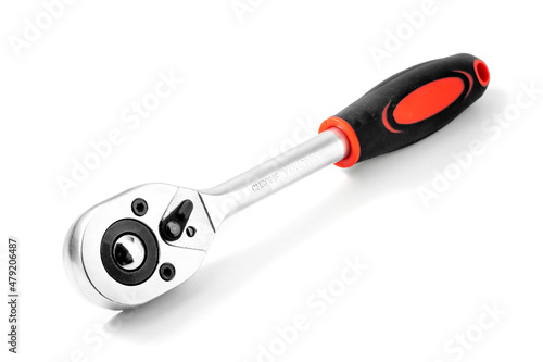 Metal wrench with replaceable attachments and a ratchet with a plastic handle. Close-up isolated on white background with shadow.