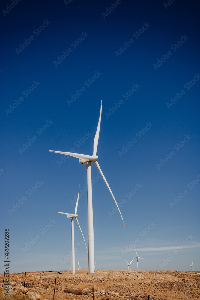 Windmills for electricity generation Jordan. Wind turbine farm in the desert, windmill farm producing green energy. Jordan Windmills for electricity generation Jordan. Wind turbine farm in the desert, windmill farm producing green energy. Jordan