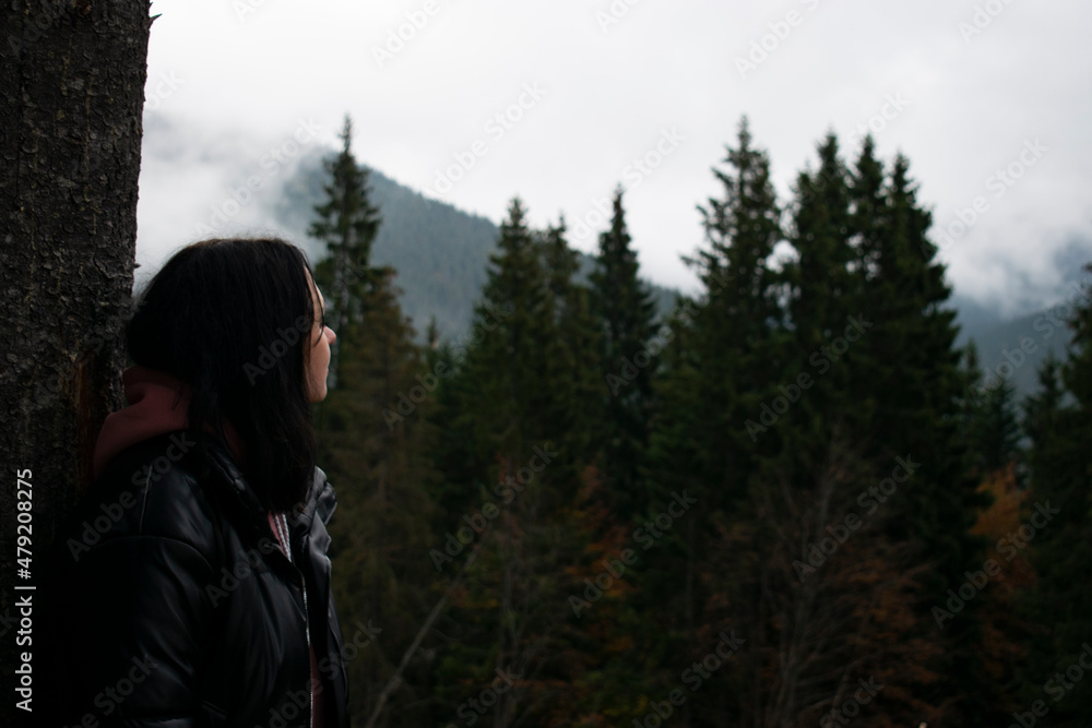 Woman in dark dress in a misty forest