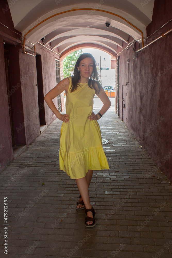 A young woman with brown hair, in a yellow dress