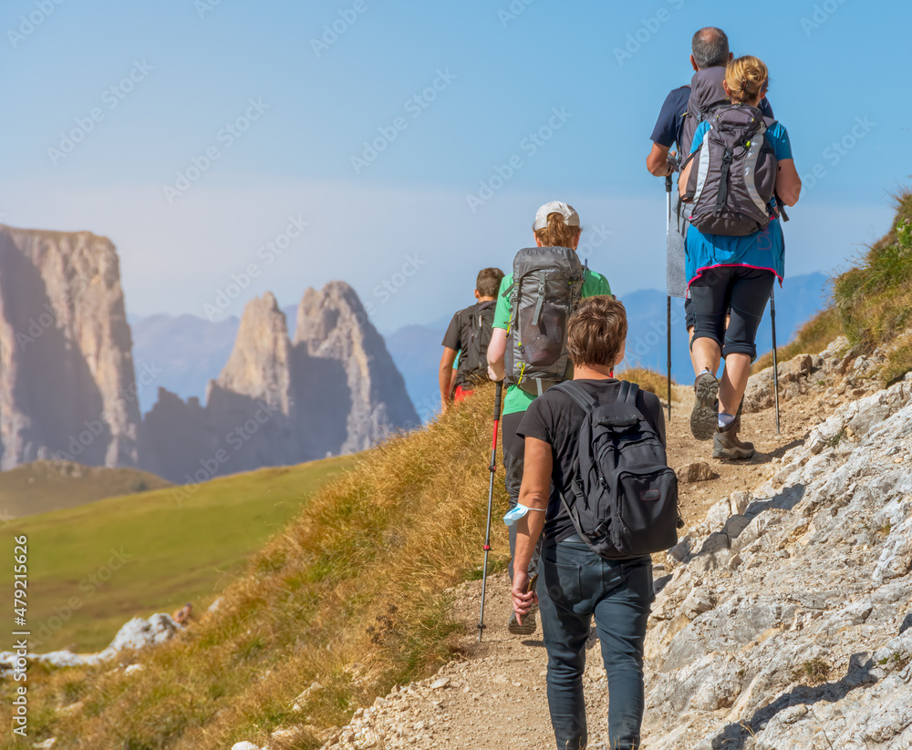 Groups of hikers on a trail in the mountain of Italian Alps. Dolomites - Sassolungo, South Tyrol. Italy 
