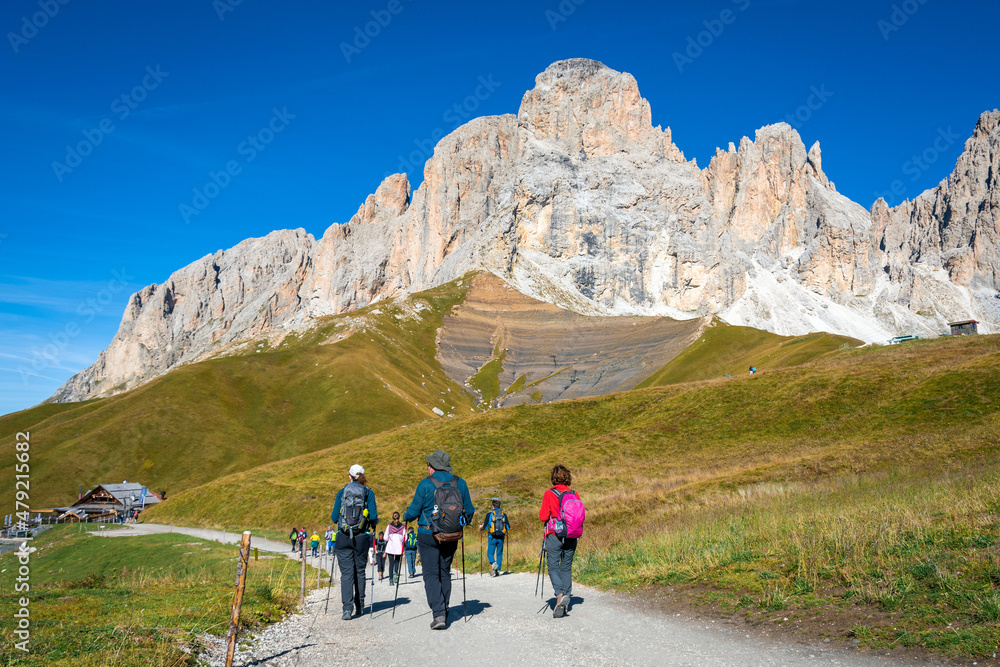 Groups of hikers on a trail in the mountains of Italian Alps. Dolomites - Sassolungo, South Tyrol. Italy 