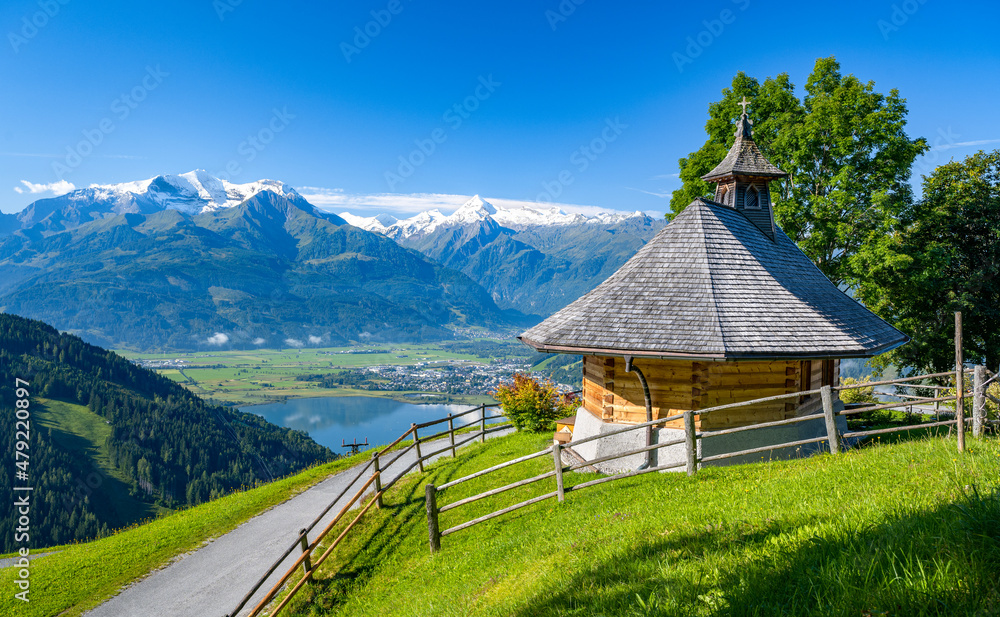 Obraz premium Small mountain chapel in Zell am See, in the background the impressive snow-covered Kitzsteinhorn, Salzburg, Austria, Europe