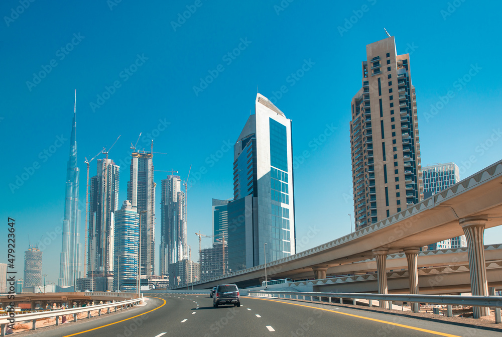 Road to Dubai, UAE. Car traffic and city skyscrapers on a sunny day. Road to Dubai, UAE. Car traffic and city skyscrapers on a sunny day.