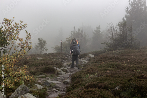 Hikers with huge backpacks on a foggy day in Vosges, France © Flo129