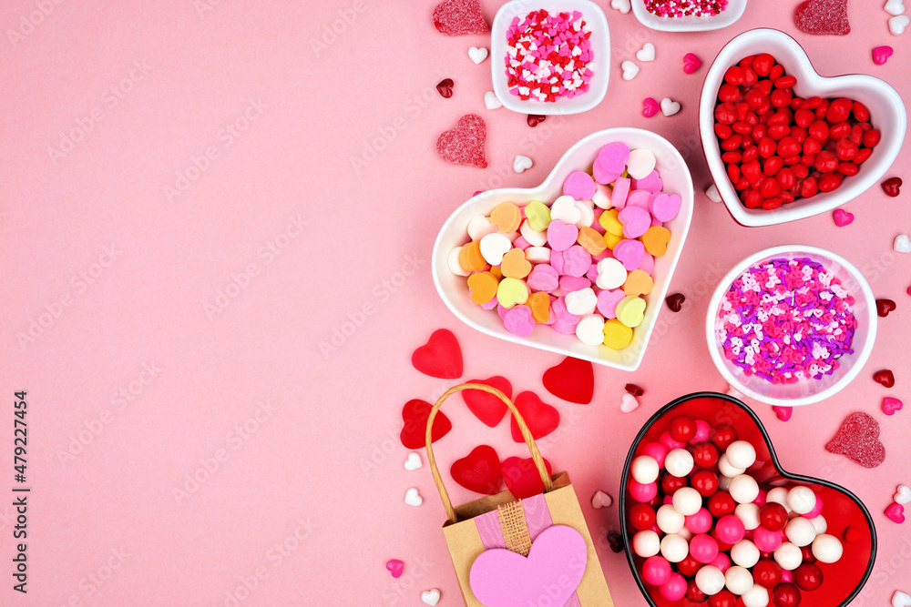 Valentines Day candy side border with assorted sweets. Overhead view on a pink paper background with copy space. Valentines Day candy side border with assorted sweets. Overhead view on a pink paper background with copy space.