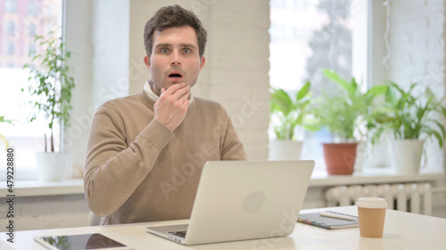 Man Feeling Shocked while using Laptop in Office