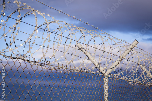 Fence with barb wire rolls on top