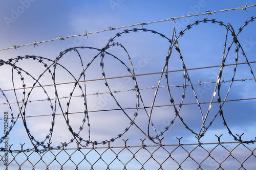 Closeup focus view of NATO barb wire with sharp and dangerous razor blades	
