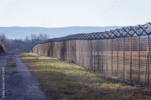 Border barrier fence with with barbed wire between two states photo