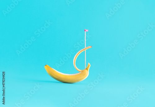 Exotic fruit against bright blue background. Creative summer layout  minimal sail boat  relaxing holiday destination. 