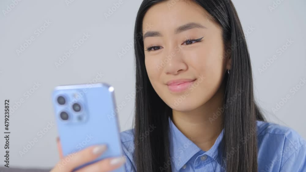 Beautiful asian girl typing message on mobile phone. Young Vietnamese woman using smart phone for online communication. BIPOC person lifestyle video clip