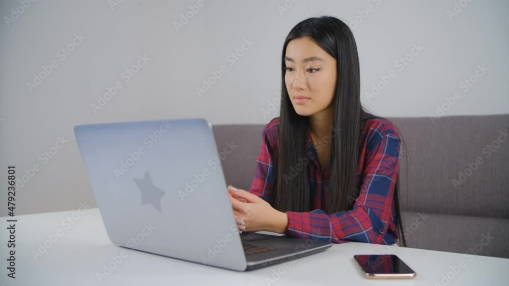 Asian student and distant learning. Beautiful Vietnamese girl listening to online teacher on video call. Young BIPOC woman from Vietnam using laptop computer and internet for education Asian student and distant learning. Beautiful Vietnamese girl listening to online teacher on video call. Young BIPOC woman from Vietnam using laptop computer and internet for education