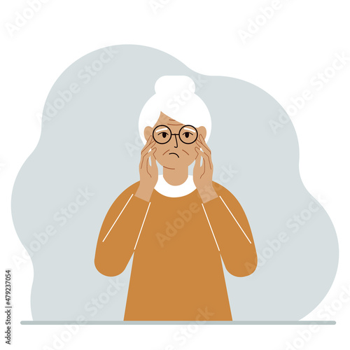 Fototapeta Naklejka Na Ścianę i Meble -  Unhappy grandmother clutching his head with his hands. Emotions and body language concept. Stress, tension and migraine concept.