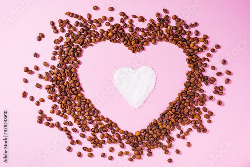A cup of black coffee on a purple background with hear shape around made from coffee beans. Ideal concept for cheer coffee day, international barista day or anything related to coffee