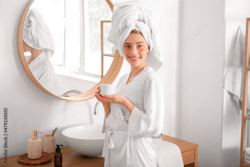Pretty young woman with under-eye patches drinking coffee in bathroom Pretty young woman with under-eye patches drinking coffee in bathroom
