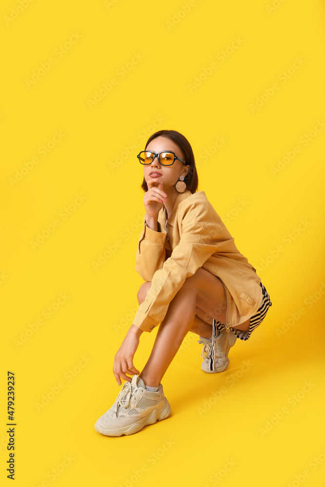 Fototapeta premium Pretty young woman in stylish clothes on color background