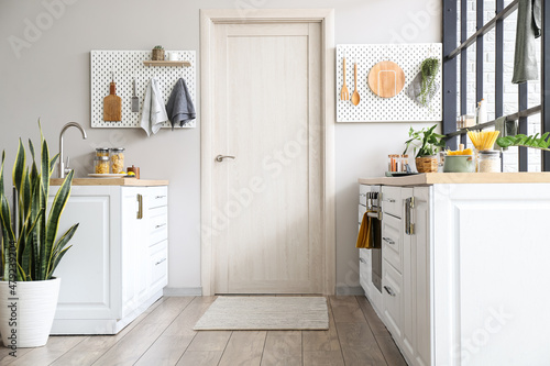 Obraz na plátne Interior of modern kitchen with white counters, door and peg boards