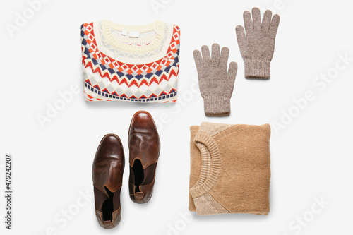 Male sweaters, gloves and shoes on white background