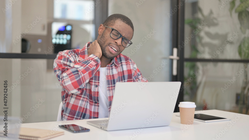 African Man having Neck Pain while using Laptop African Man having Neck Pain while using Laptop