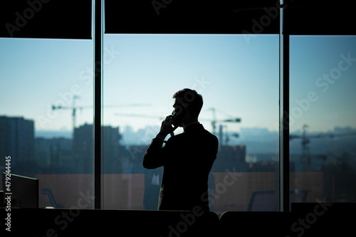 Tableau sur toile Silhouette of a businessman man in a modern office on the background of the wind