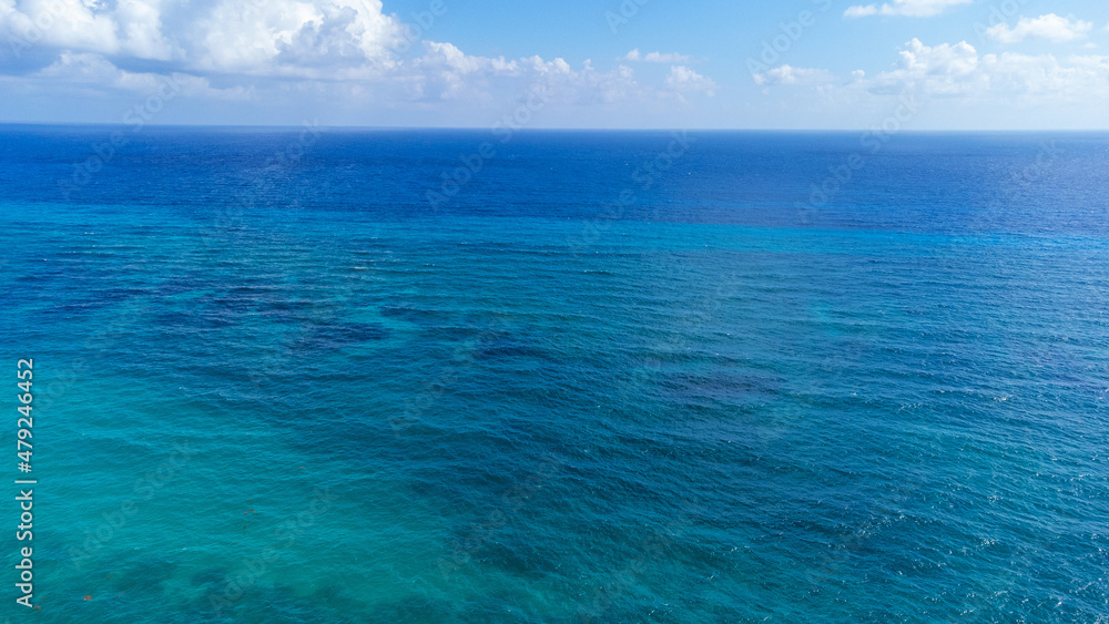 Vibrant turquoise blue ocean water in the Caribbean sea off the shore of Cozumel, Mexico. The sea is clear and you can see the coral reef under the surface. Vibrant turquoise blue ocean water in the Caribbean sea off the shore of Cozumel, Mexico. The sea is clear and you can see the coral reef under the surface.