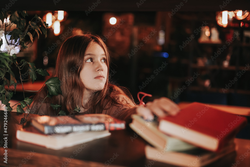 A cute teenage girl reading book in cafe. Education, leisure, hobby, back to school concept. A cute teenage girl reading book in cafe. Education, leisure, hobby, back to school concept.