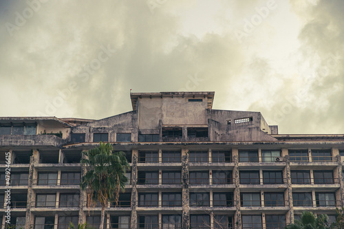 An abandoned and empty resort hotel on a tropical island beach shows decay and age photo