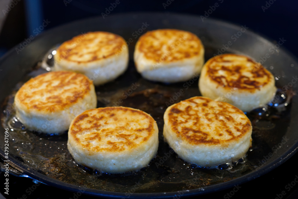 Cottage cheesecakes are fried in a frying pan. The process of cooking delicious homemade food. cheese pancakes or syrniki. close up