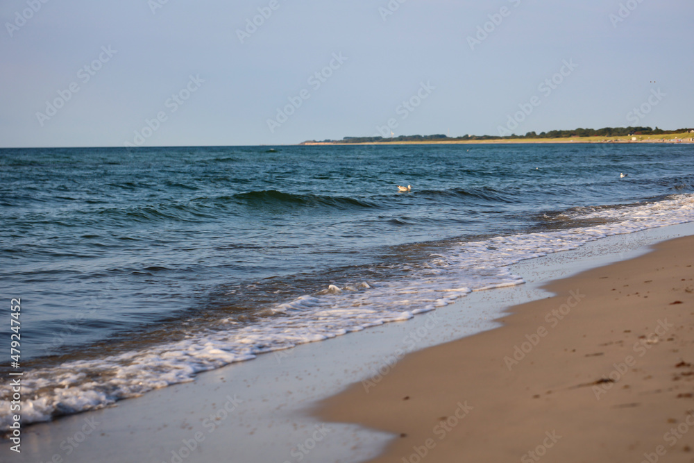 Wellen mit weißen Schaum am Strand der Ostsee.
