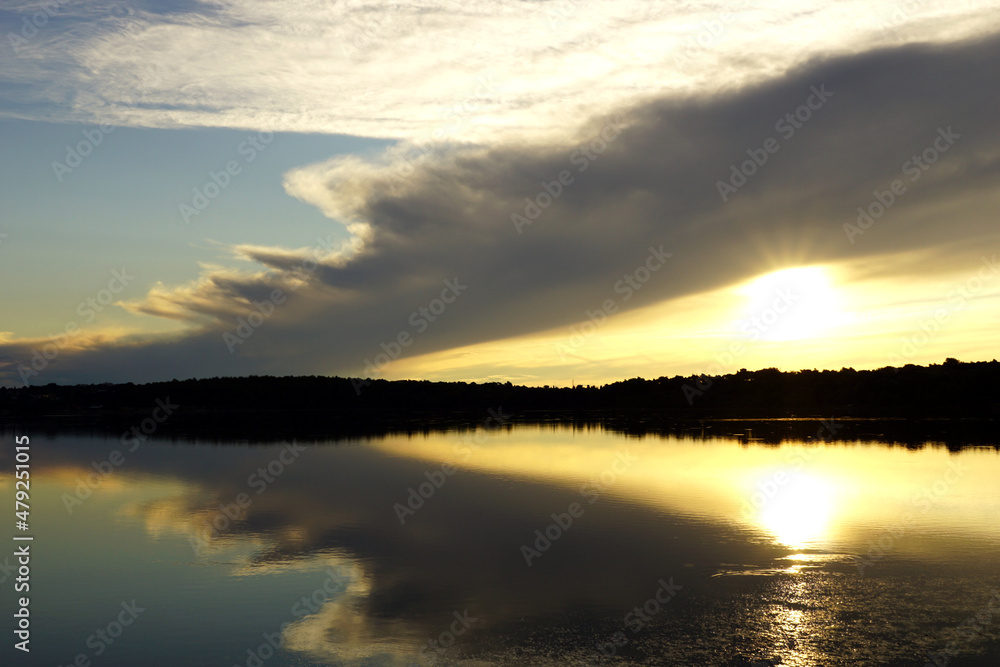 Seashore landscape sunset with cloudy sky and reflection in the water
