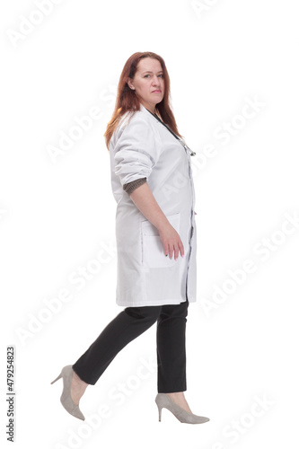 mature woman doctor striding forward. isolated on a white background. © ASDF