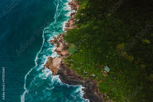 Scenic coastline with house, rocks and ocean with waves in Brasil. Aerial view