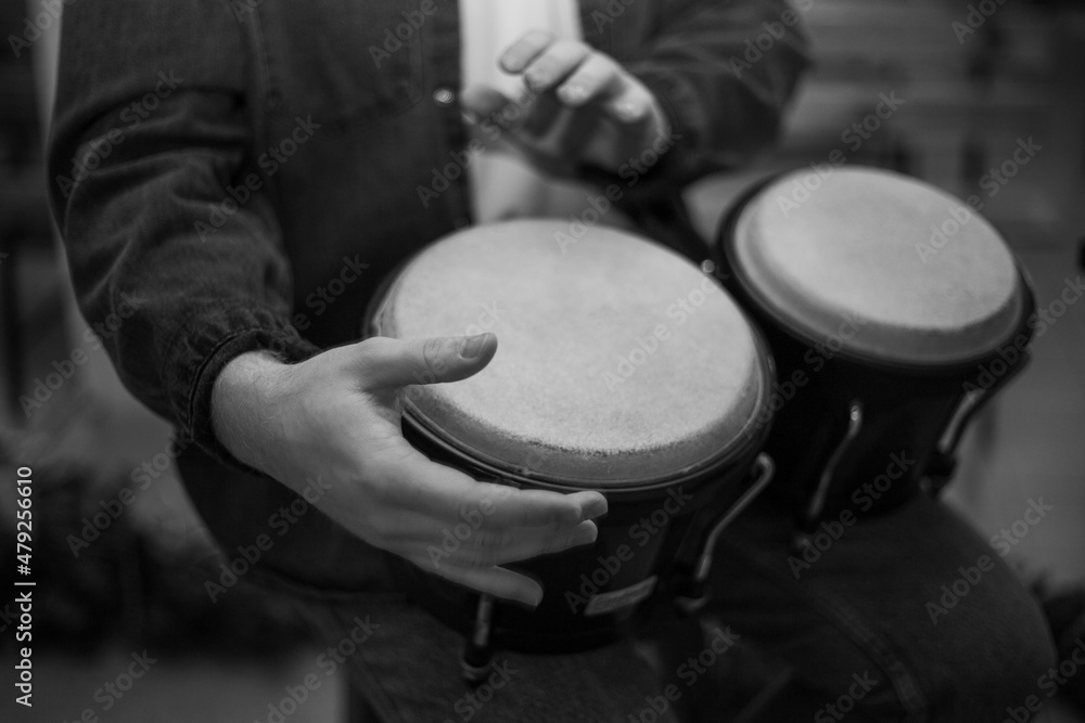 A young guy with a beard plays percussion bongos A young guy with a beard plays percussion bongos