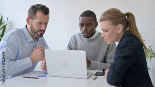 Tense Business People Waiting for Results on Laptop in Office