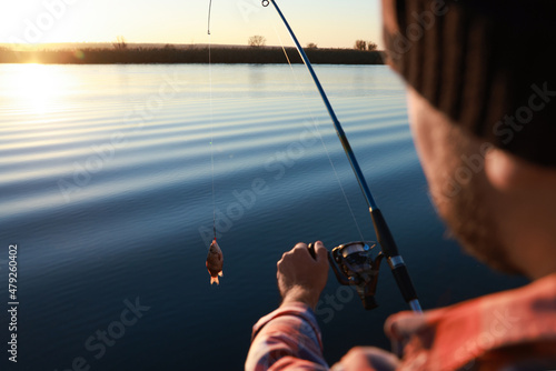 Canvastavla Fisherman catching fish with rod at riverside, closeup