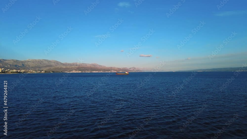 Cinematic view of a small boat in the middle of Adriatic sea in Croatia. With clean blue water with waves, hills in the background along with the city on the coastline. An amazing travel destination Cinematic view of a small boat in the middle of Adriatic sea in Croatia. With clean blue water with waves, hills in the background along with the city on the coastline. An amazing travel destination