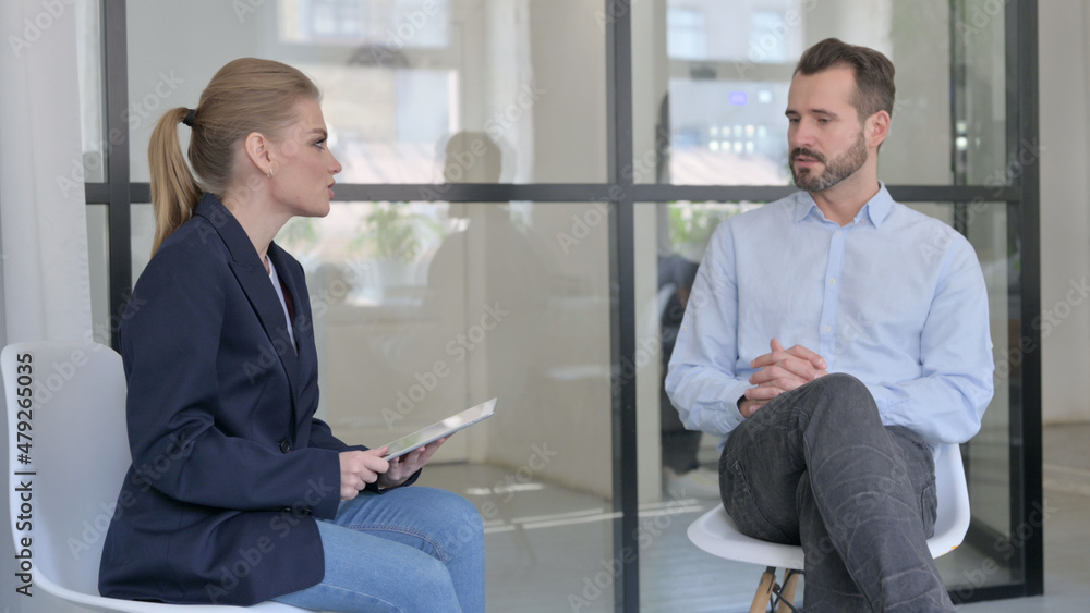 Young Businesswoman with Tablet Interviewing Businessman Young Businesswoman with Tablet Interviewing Businessman