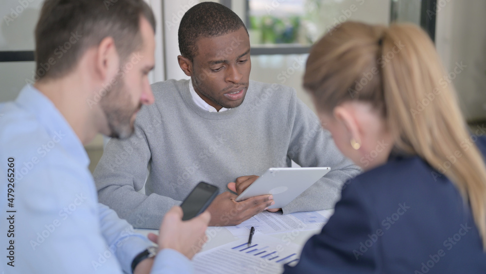 Business People using Tablet and Smartphone during Discussion