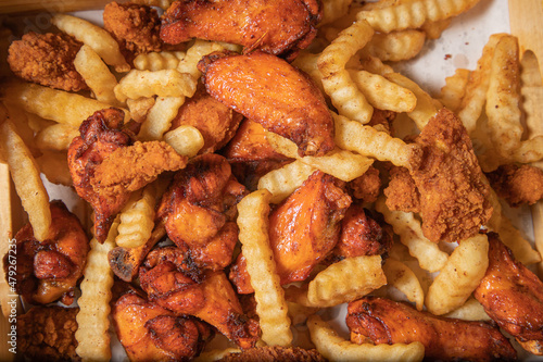 Foto Platón de botanas en bar, alitas chiken wings, papas fritas french fries y bonel