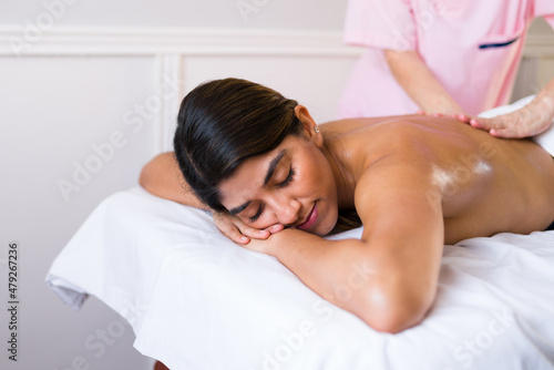 Happy latin woman enjoying a spa treatment