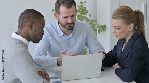 Business People with Laptop Dicsussing Project in Office photo