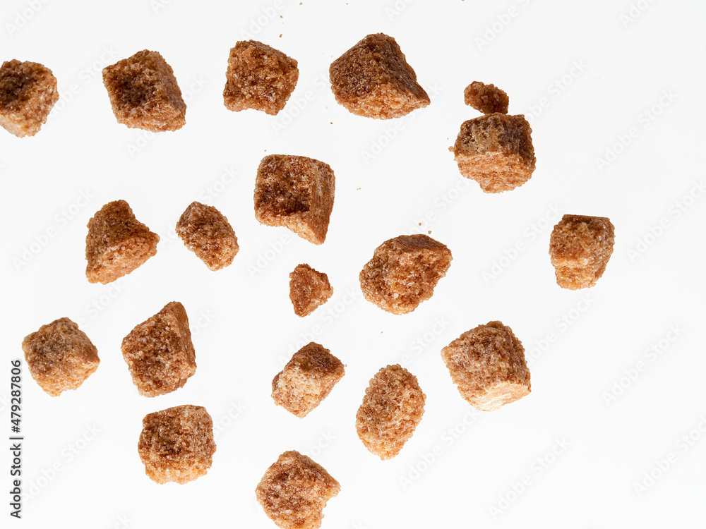 Pile of brown granulated sugar and sugar cubes isolated on white Pile of brown granulated sugar and sugar cubes isolated on white