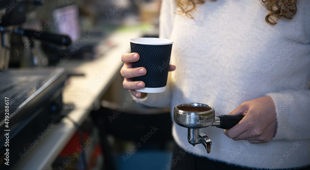 A female hand holds a holder and a glass, the process of making coffee. A female hand holds a holder and a glass, the process of making coffee.